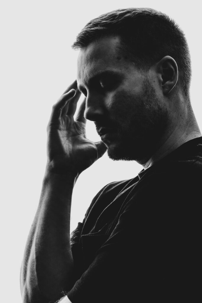 Skuteczne metody przełamywania negatywnych nawyków myślowych. Thoughtful black and white portrait of a man in deep reflection.
